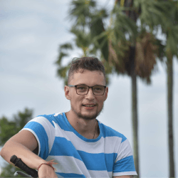 Smiling person outdoors near palm trees