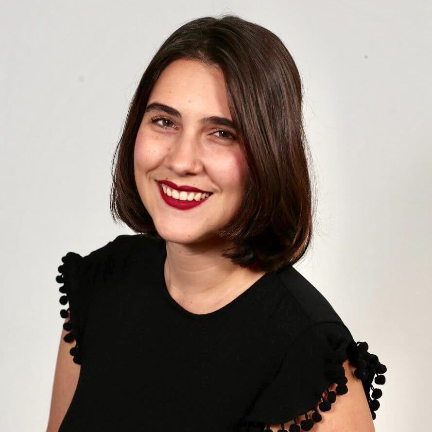Smiling woman in black top against white background.