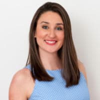 Smiling woman in blue dress, white background.