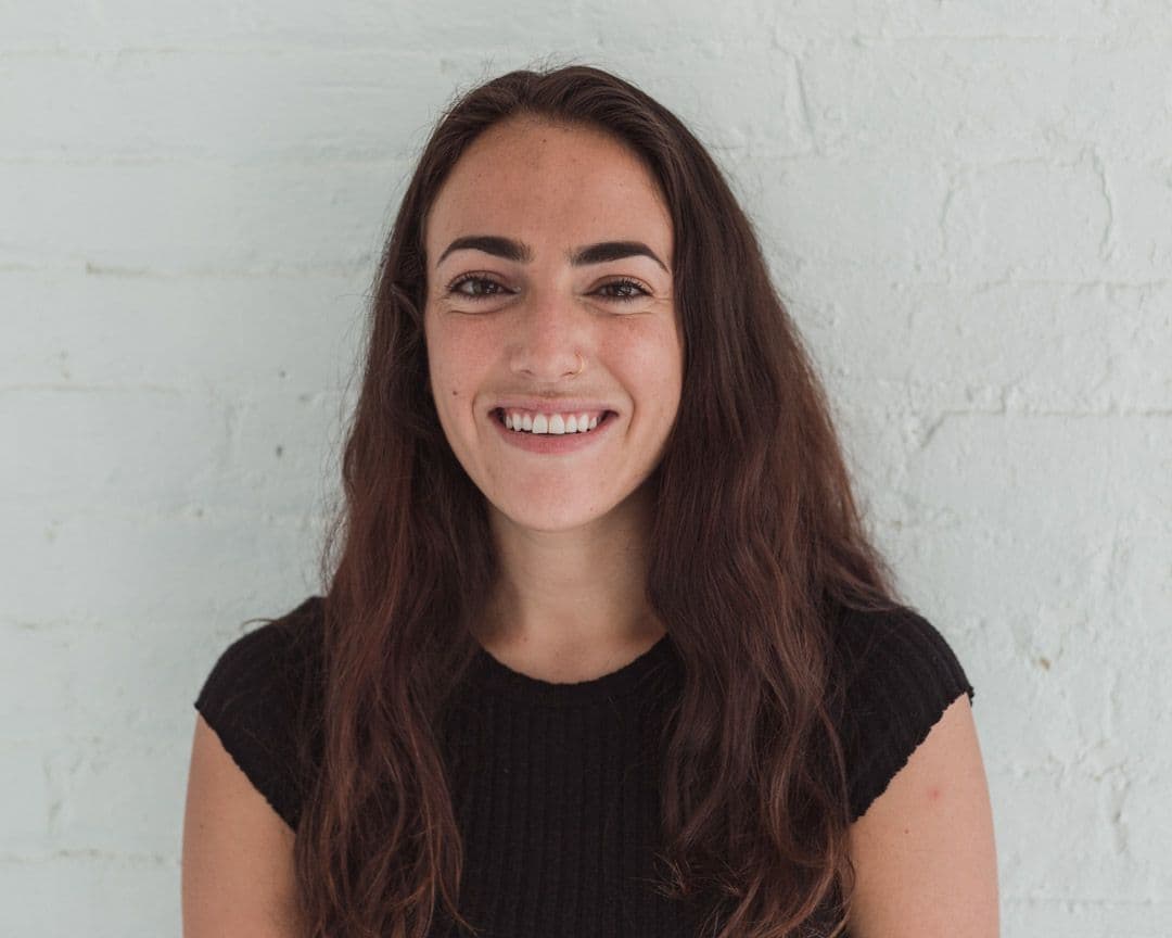 Smiling person with long hair, black shirt.