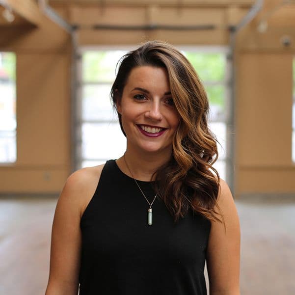 Smiling woman in black top, indoors.