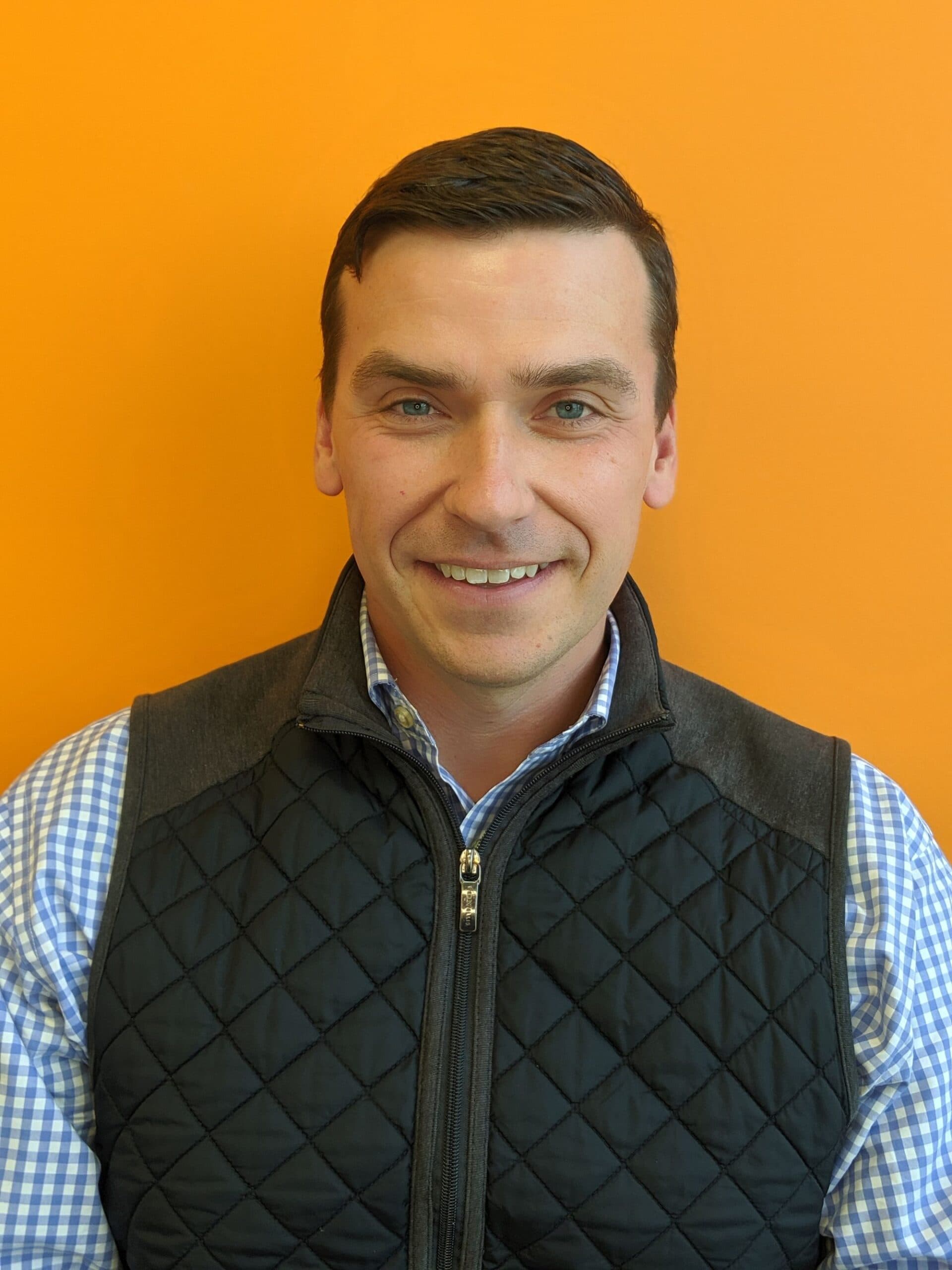 Smiling person against orange background