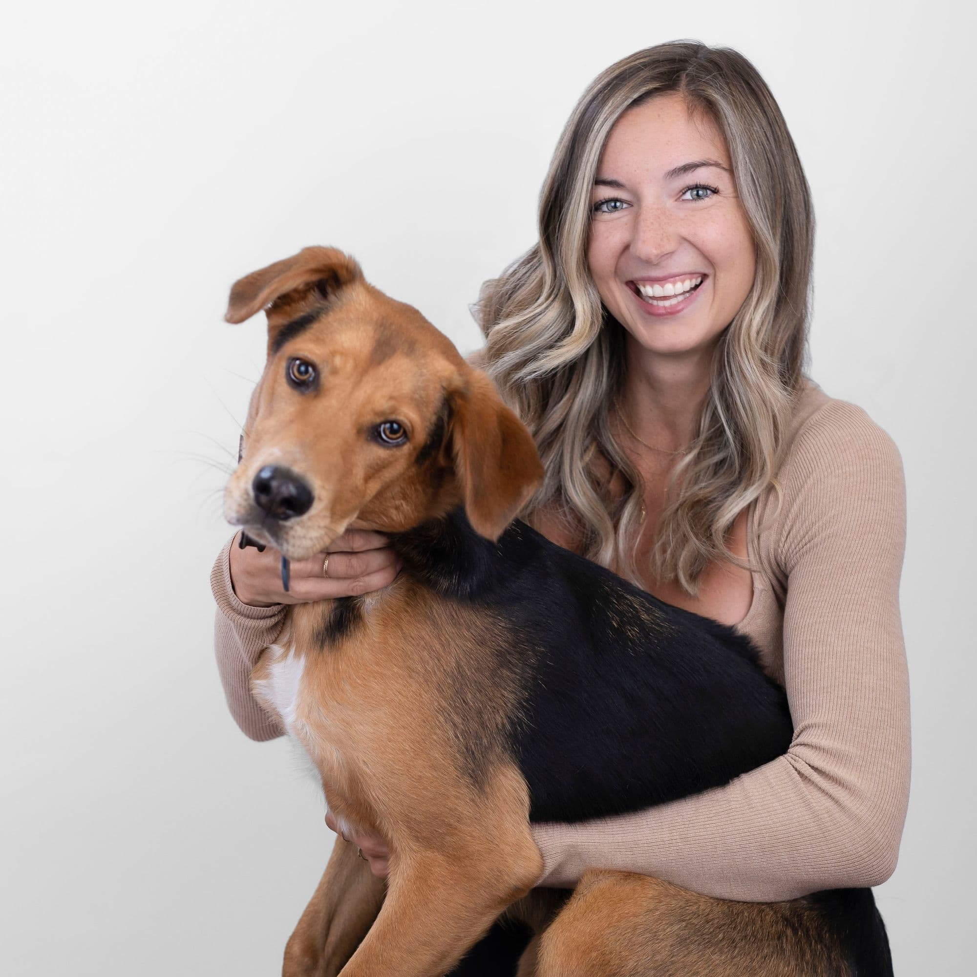 Smiling woman holding a playful dog
