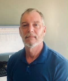 Man in blue shirt at office desk
