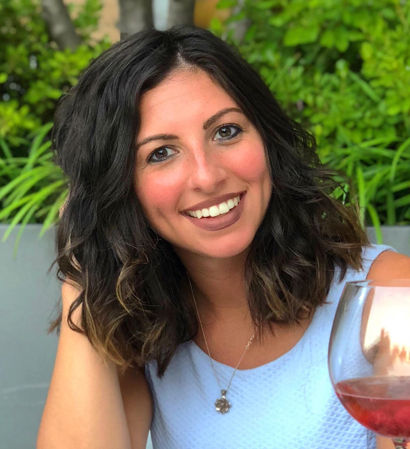 Smiling woman enjoying a drink outdoors