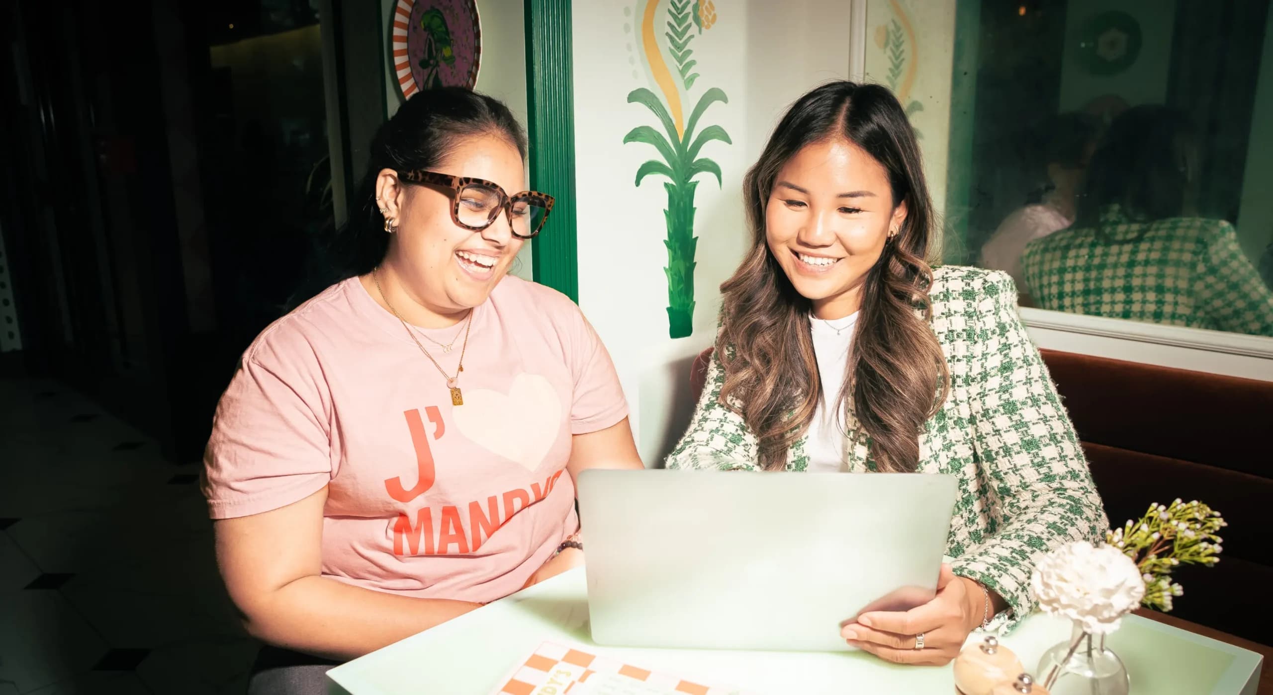 The regional manager and store manager at Mandy's Salads looking at the 7shifts app on a laptop and smiling