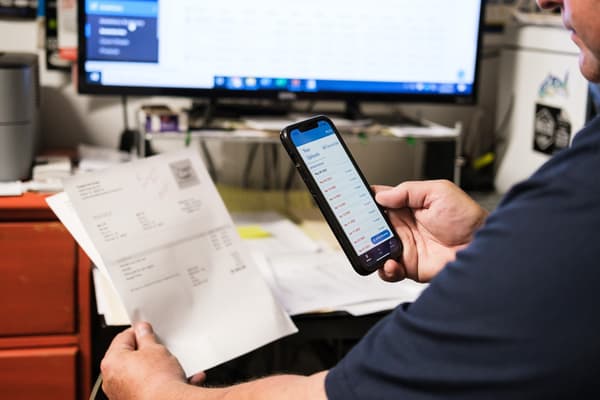 Person using phone app to manage invoices.