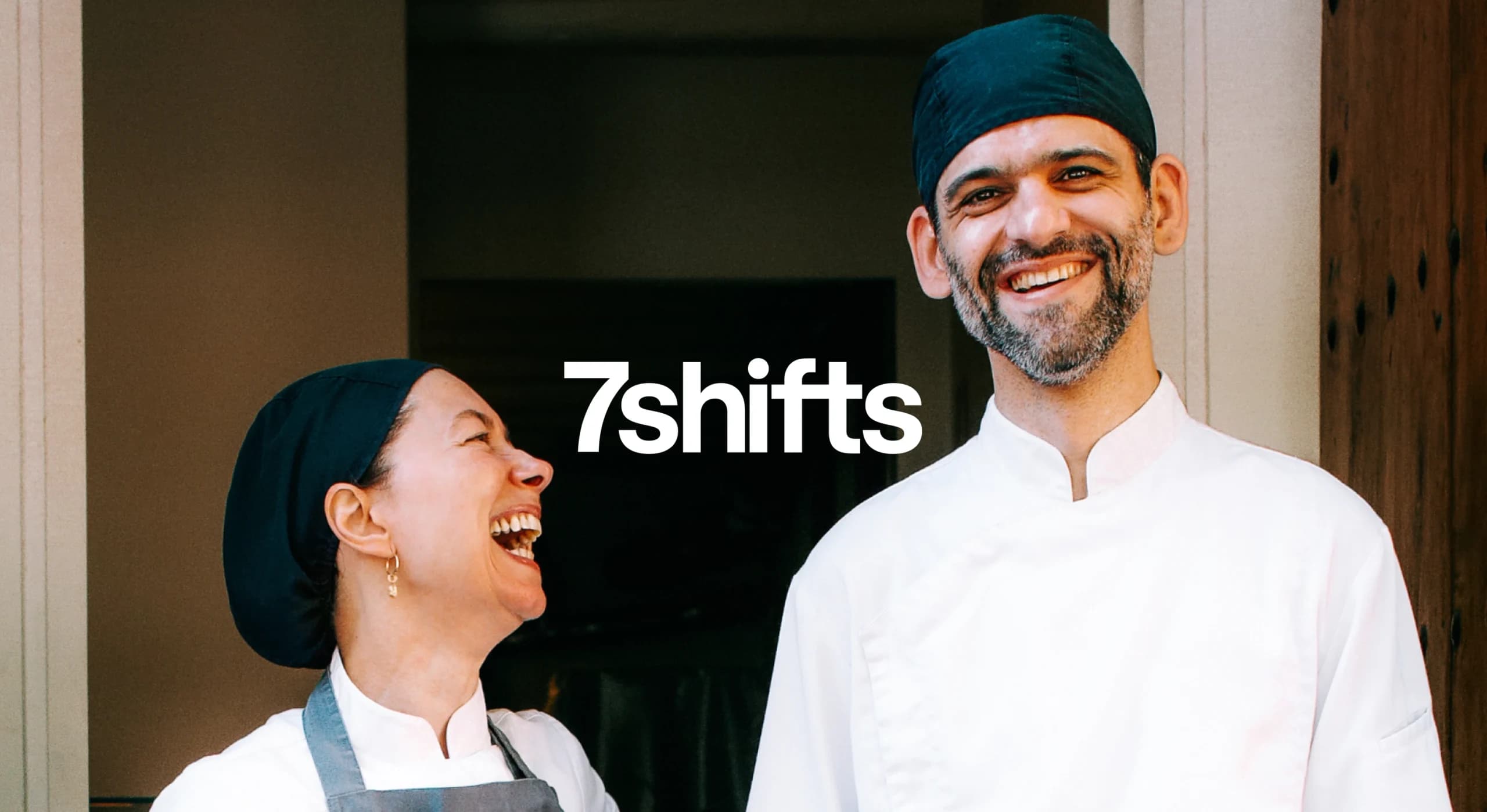 Male and female chef smiling and laughing.