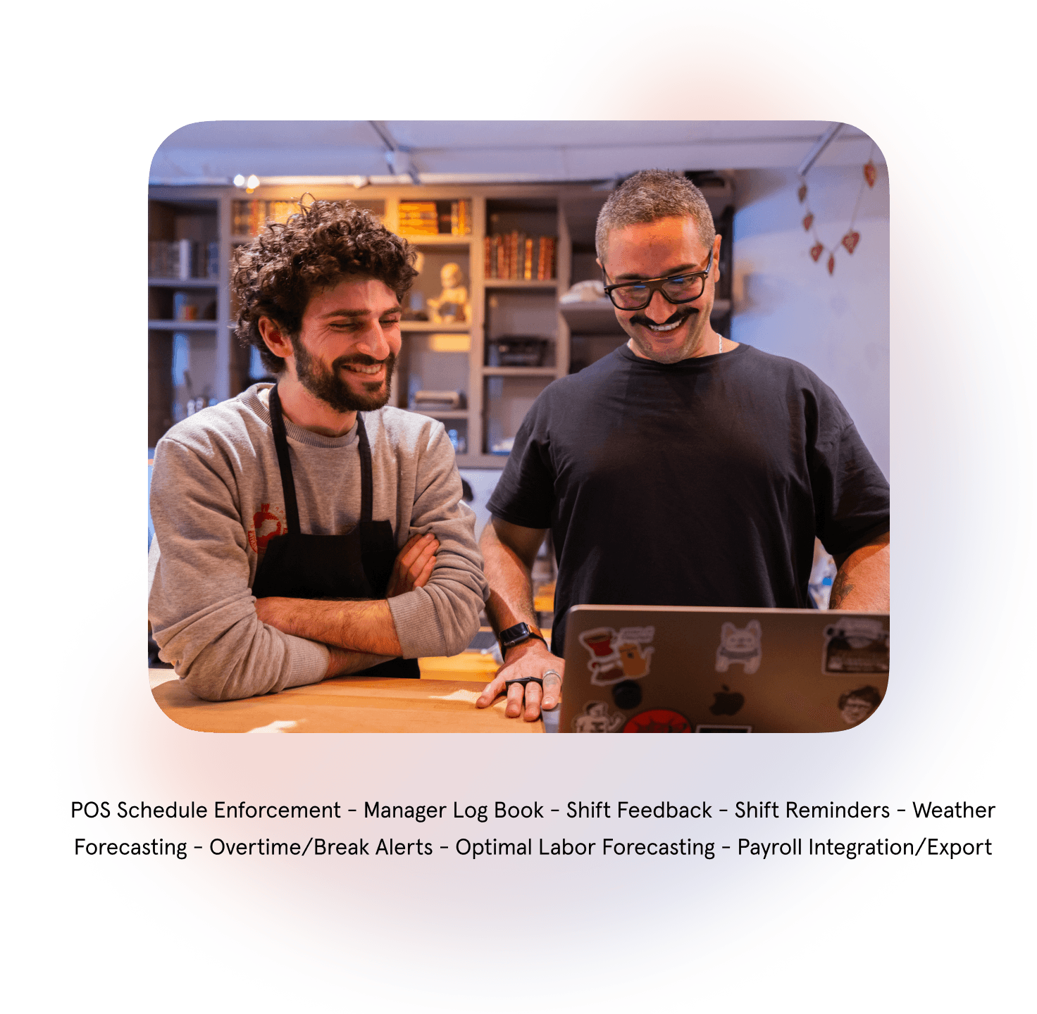 Two men smiling at laptop in cozy room