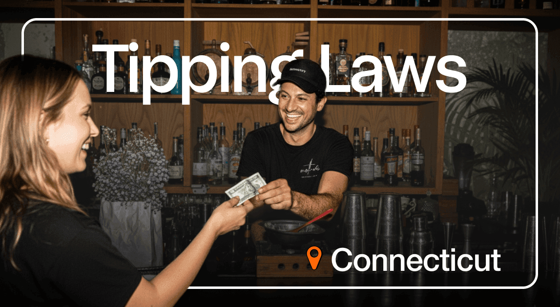 Smiling bartender receiving tip in Connecticut bar.