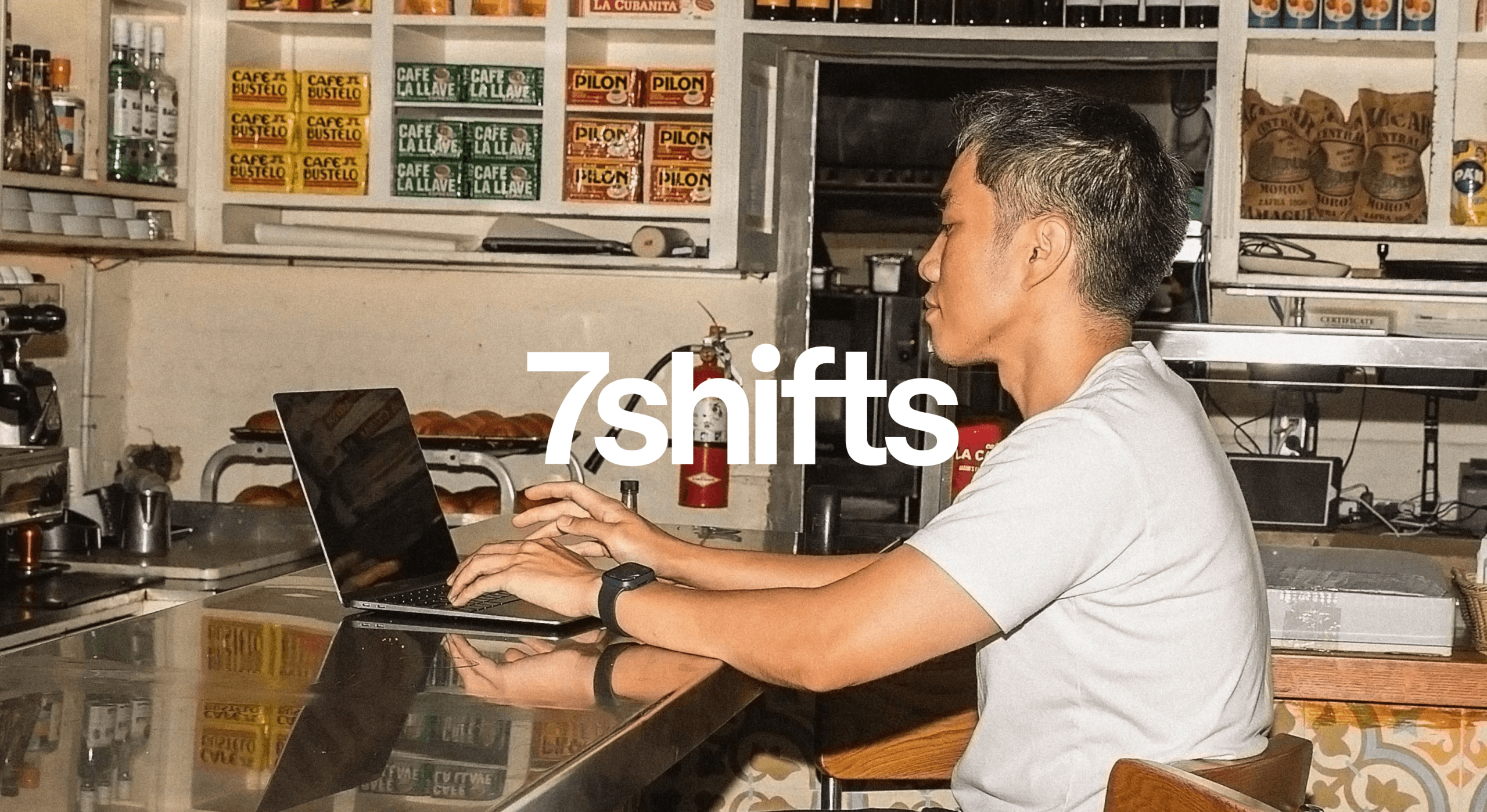 Person using laptop in a cozy cafe space.