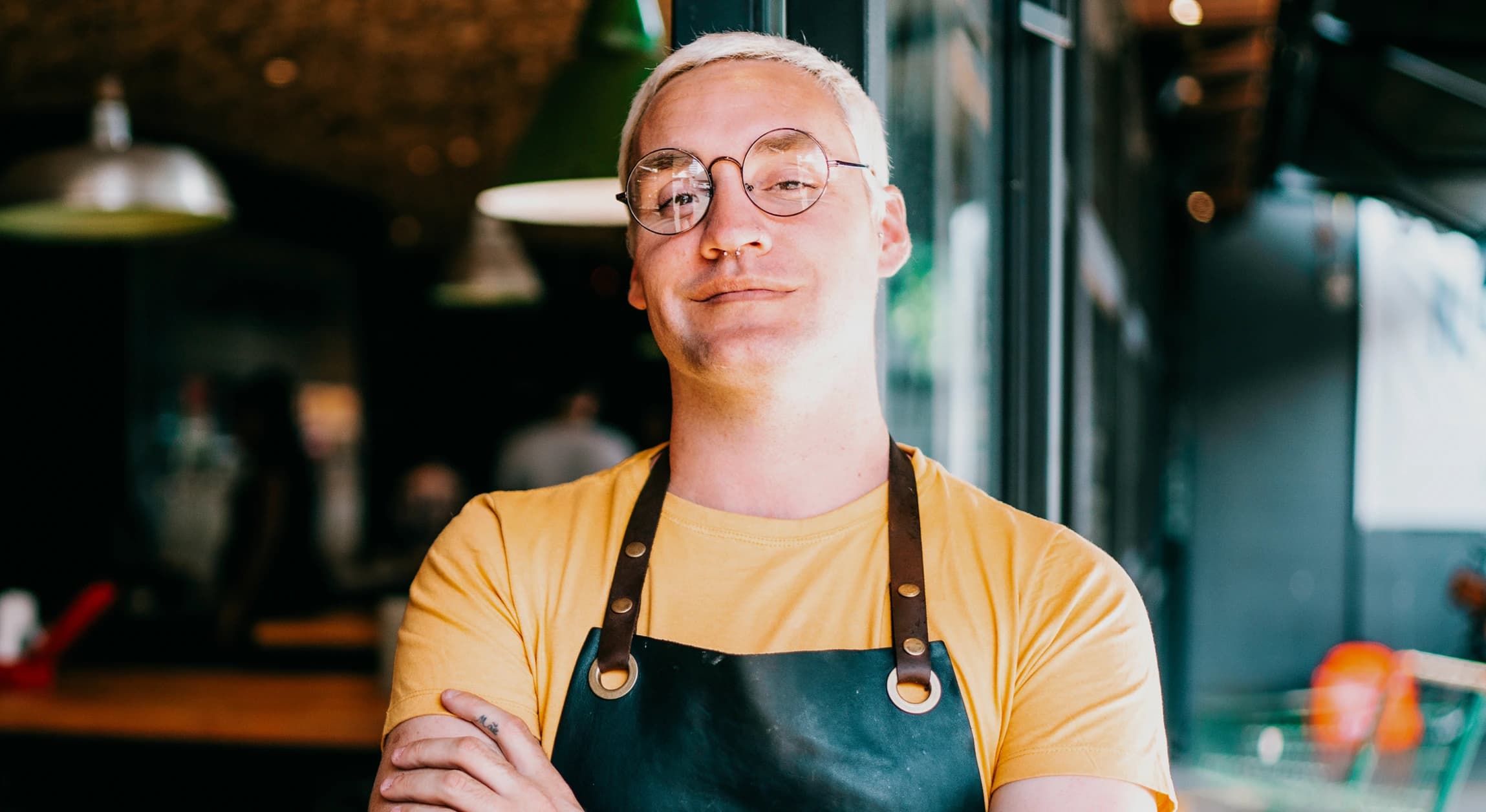 Confident chef with glasses in apron smiling