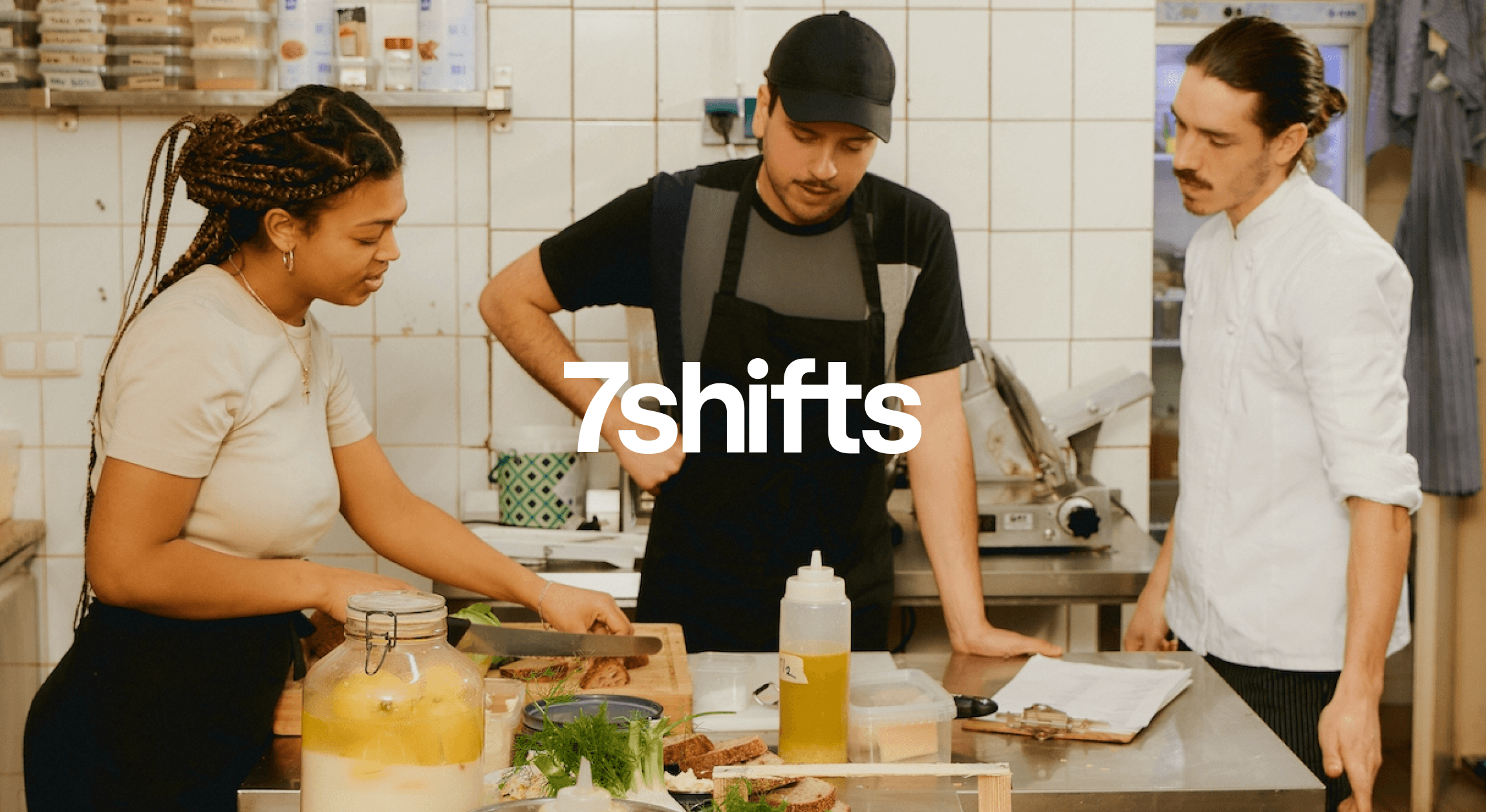 Three cooks prepping food in the kitchen.