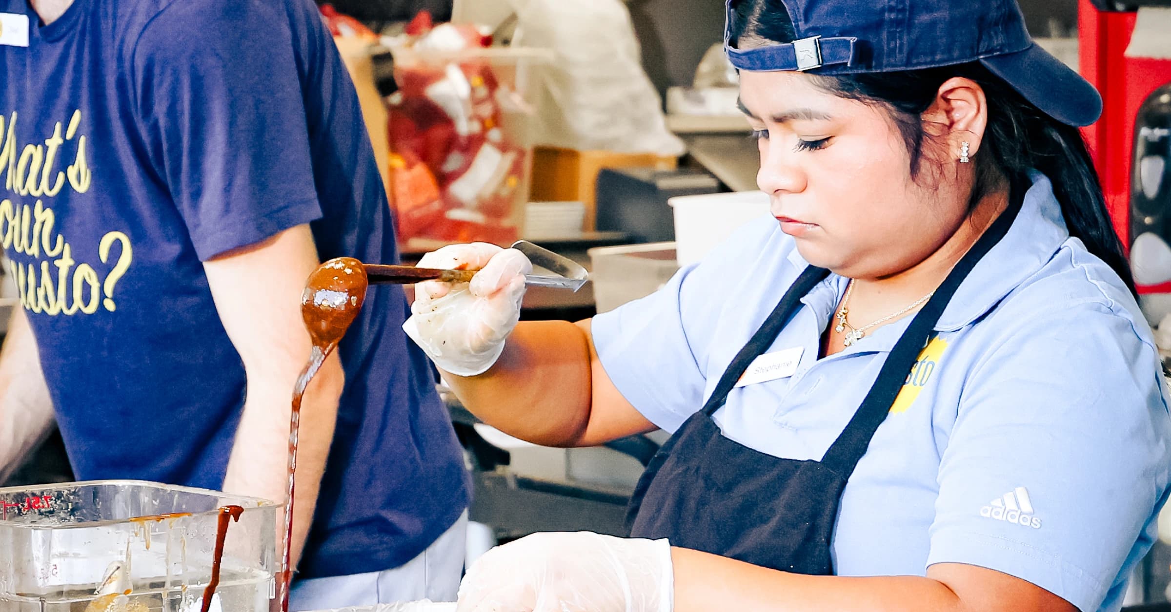 Employee scooping food in the restaurant kitchen