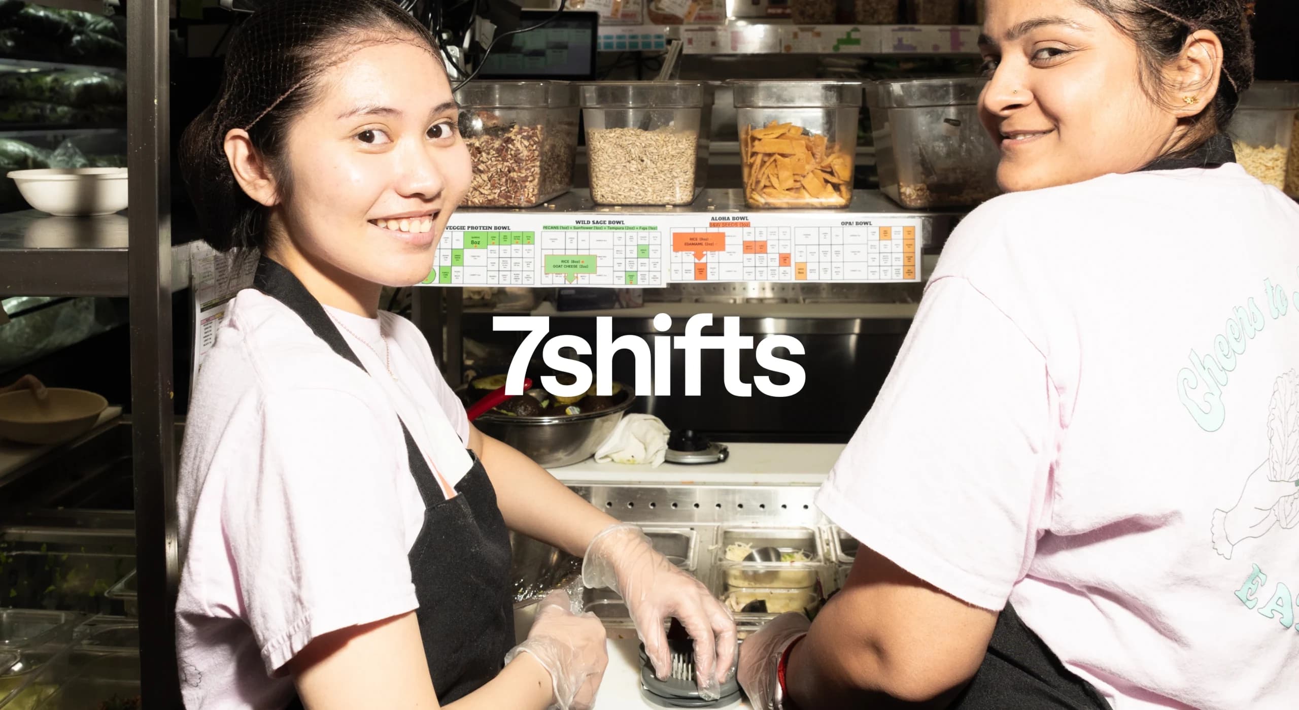 Two female employees smiling in restaurant pass