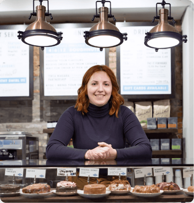 Beechwood doughnut employee leaning over doughnut counter