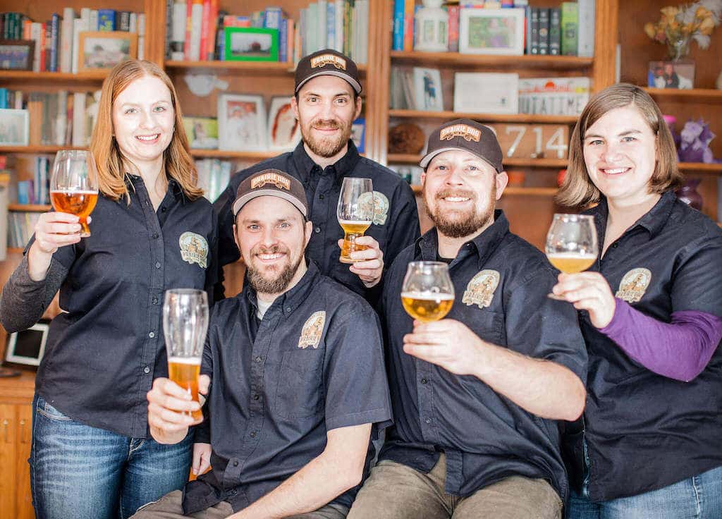 Prairie Dog Brewing employees holding pints of beer